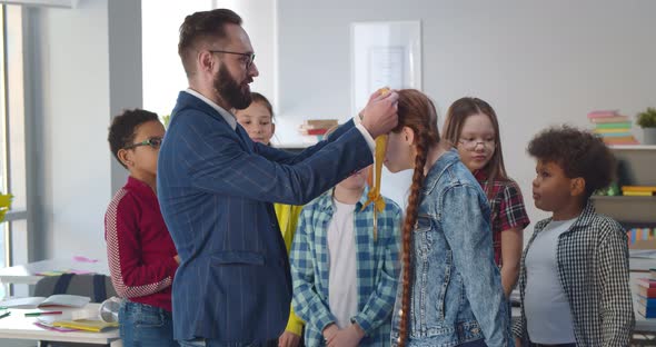 Male Teacher Awarding Schoolgirl with Medal for Best Scientific Project