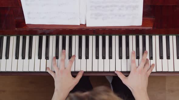 Talented female hands playing the piano, closeup, top view. Concept of playing a musical instrument