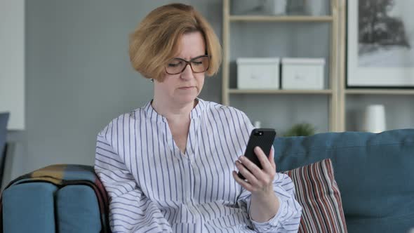 Old Woman Upset for Loss while Using Smartphone