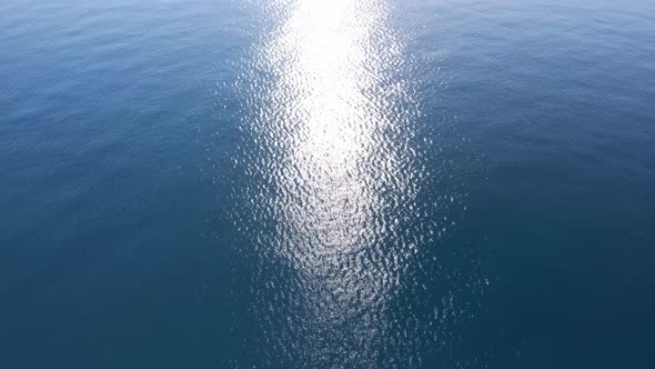 Infinite sea down view on morning sun reflection