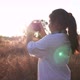 Girl standing in meadow and taking a picture by camera - VideoHive Item for Sale