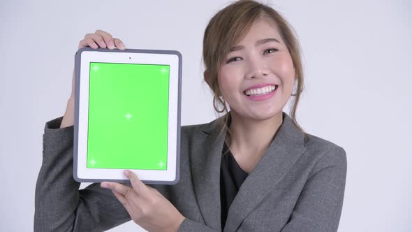 Face of Young Happy Asian Businesswoman Showing Digital Tablet