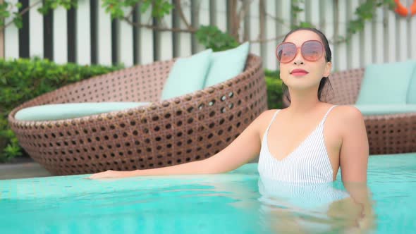 Young asian woman enjoy around outdoor swimming pool for leisure