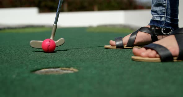 Girl playing miniature golf in the garden 4k