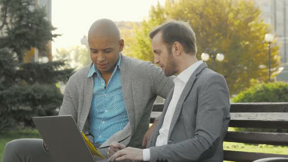 Handsome Young Businessman Talking To His Colleague in City Park