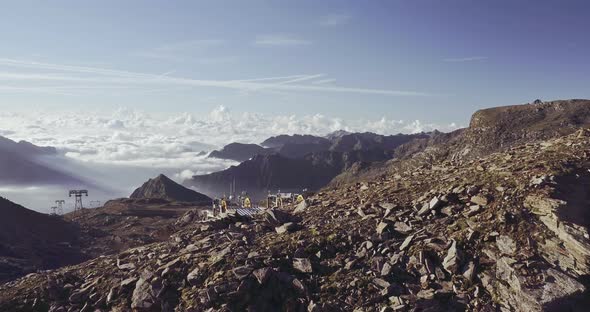 Aerial View of Rocky Mountain Cliff. Beautiful Landscape in Background, Clouds Cover Lower Mountain