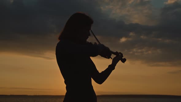 Silhouette of Woman Playing Violin