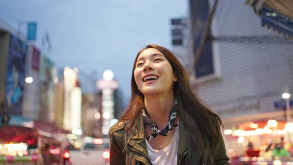 Asian happy and chreerful woman backpacker travel alone on night street.
