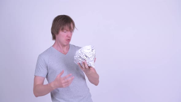 Young Man with Tinfoil Hat Showing Air Guitar Gesture