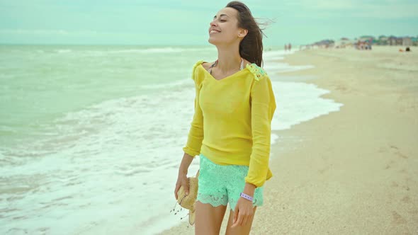 Portrait Happy Expression Woman with Blowing Hair Wearing Yellow Shirt Having Fun on Beach and