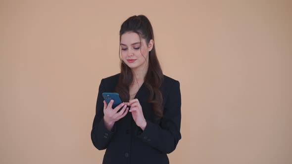 Young Business Woman Bunet Hair Dressed Black Suit Holding Mobile Phone Laughs Standing Studio