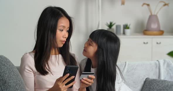 Asian Family Young Mother with Her Beloved Daughter Sitting Together in Modern Living Room Mother