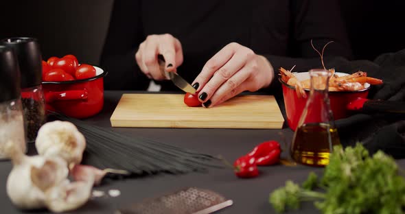 Woman's Hands Cut Tomato for Dinner with a Knife