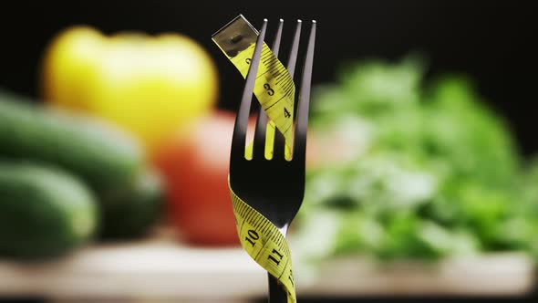 Yellow Measuring Tape on the Fork and Fresh Vegetables on a Wooden Cutting Board