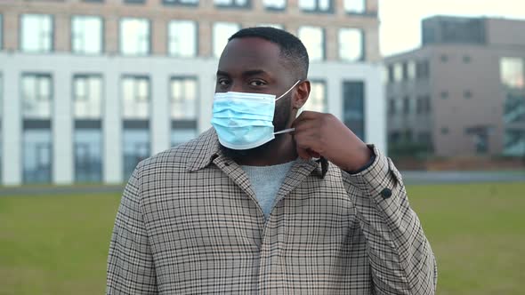 Smiling AfricanAmerican Man Putting Protective Medical Mask Off