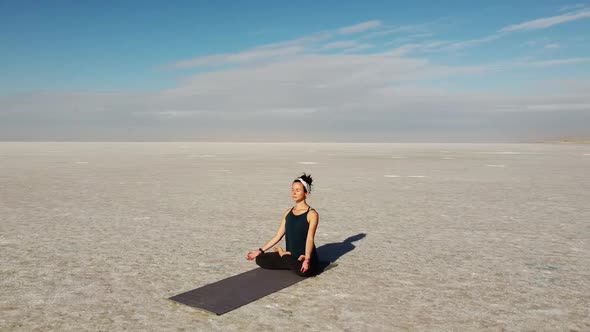 Beautiful girl praticing meditation pose on the Lake Tuz, Salar in Turkey. Good vibes and energy. Pe