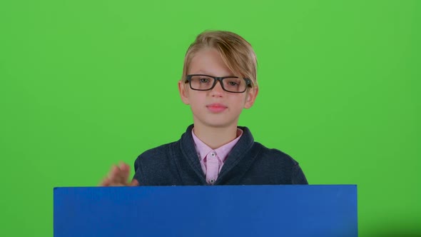 Teenager in Glasses Emerges From Behind the Board and Waving on a Green Screen