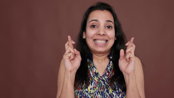 Indian Woman Holding Fingers Crossed for Good Luck in Studio