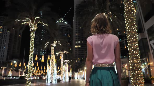 A Young Woman Is Walking Along the Evening Dubai.