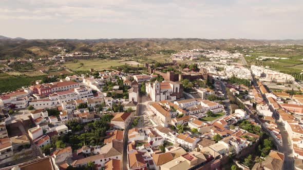 Fly-over old town Silves towards historic Cathedral and Moorish Castle