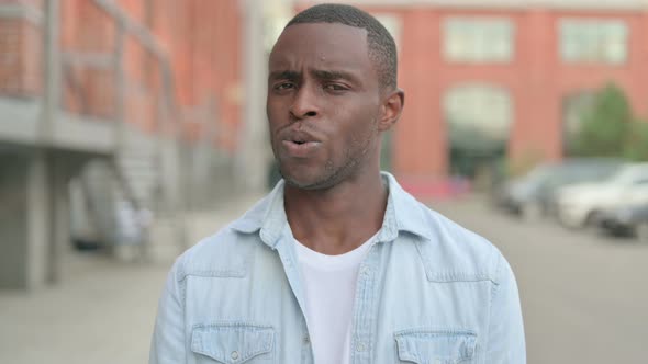 Outdoor Portrait of African Man Shaking Head As No Sign Denial