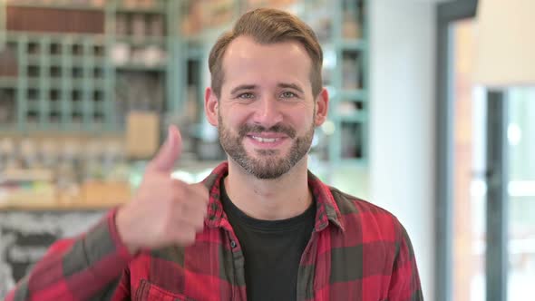 Portrait of Thumbs Up By Approving Young Man