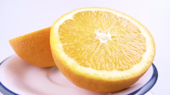 Close up fresh valencia orange sliced with white background shallow focus and slowly rotating.