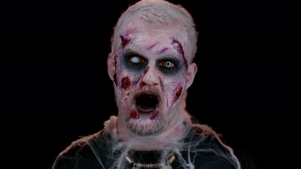 Frightening Man with Halloween Zombie Bloody Wounded Makeup Face Scare Expressions Convulsions