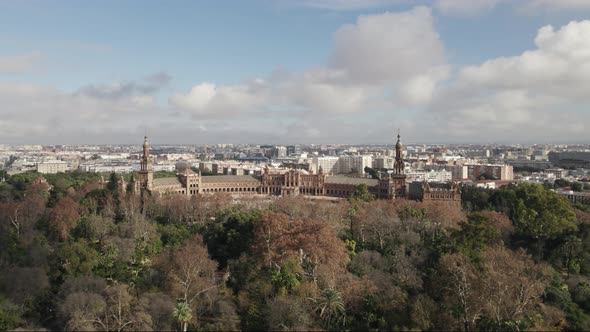 Fly over Maria Luisa Park towards Plaza de Espana, Spain Square, in Seville. Aerial forward