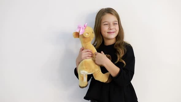 A Child with a Soft Toy on a White Background She Tenderly Hugs the Toy