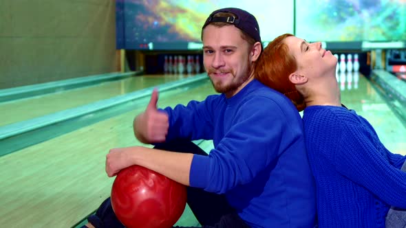 Boy and Girl Show Their Thumbs Up at the Bowling