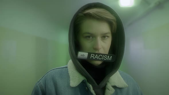 Woman in a Hood and Denim Jacket Holds a Sign with Inscription  STOP RACISM