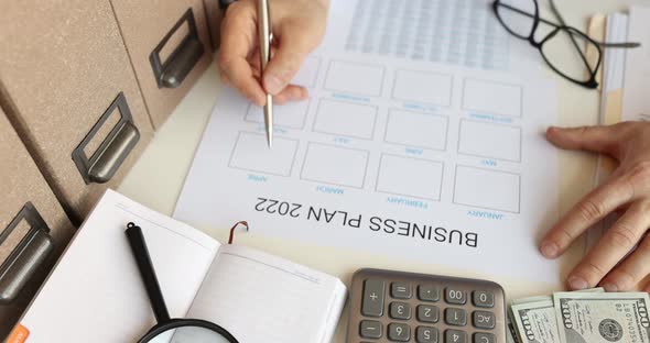 Businessman Sitting at Table and Studying Business Plan for 2022  Movie