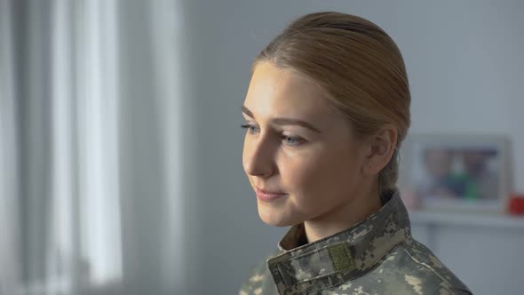 Happy Female Soldier in Camouflage Uniform Watching Military March in Window