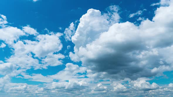 White Fluffy Clouds Slowly Float Through the Blue Daytime Sky Timelapse