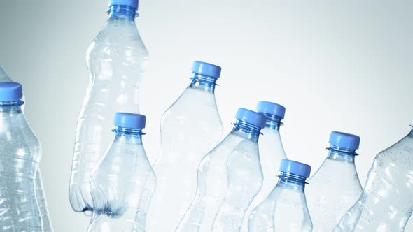 Super Slow Motion Shot of Flying Empty Plastic Bottles on Light Blue Gradient Background at 1000Fps.