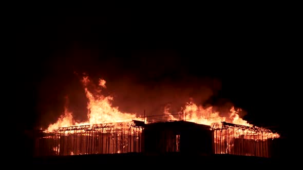 Slow motion burning fire flame on residential building roof at night