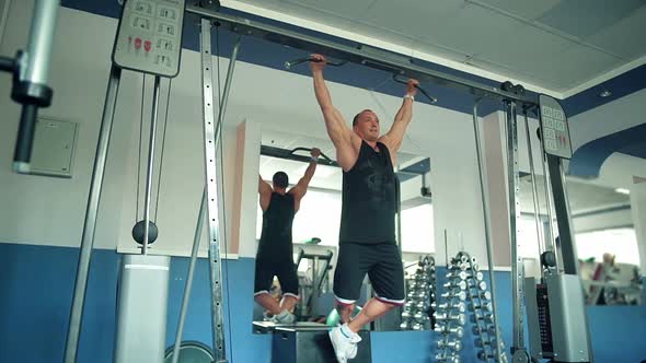 Athlete Doing Pullup on Horizontal Bar in the Gym