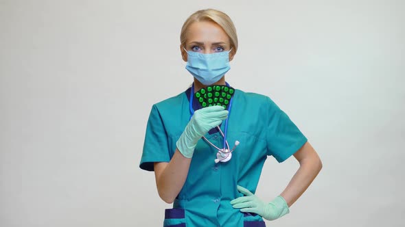Medical Doctor Nurse Woman Wearing Protective Mask and Rubber or Latex Gloves - Holding Pills