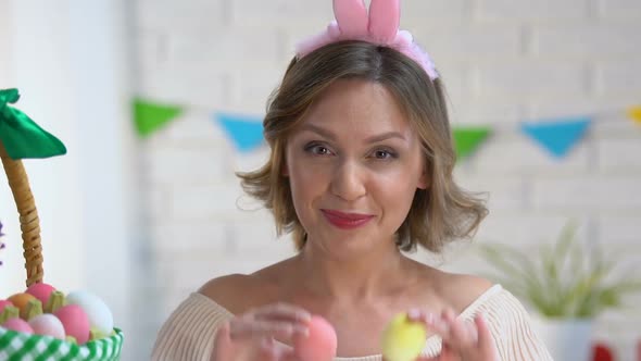 Cheerful Woman Having Fun Holding Brightly Colored Easter Eggs Near Eyes, Mood