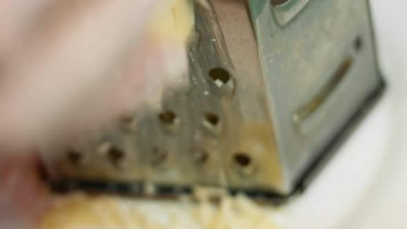 Slow motion of A cook grater Parmesan cheese, typical Italian cheese, on the plate just freshly brew