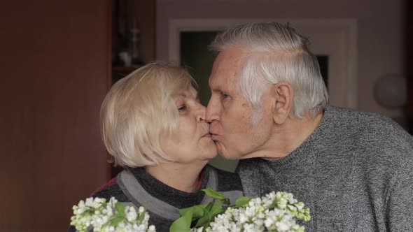 Portrait of a Happy Grandfather and Grandmother. Grandma Kissing Gandpa