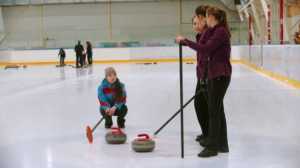 Curling Training - the Judge Measuring the Distance Between Two Stones on the Ice Rink