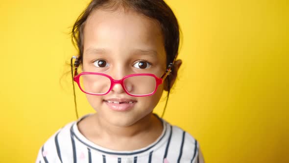 Child Girl Suffering Pain on Eye Against Yellow Background