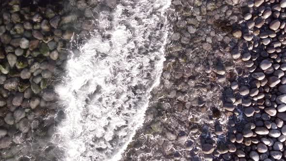 Winter Aerial Flight Top Over Waves Rolling on Artic Ocean Shore with Round Stones Ocean Waves at