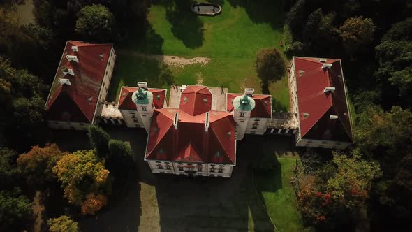 AERIAL front view of Castle. Flight over beautiful castle, located in landscape park with green tree