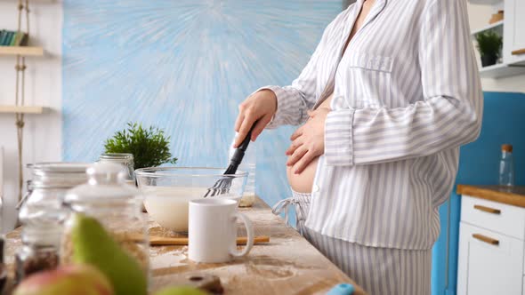 Closeup Of Pregnant Woman Cooking Food On Kitchen