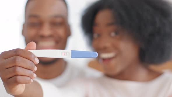 Excited African Married Couple Showing Positive Result of Pregnancy Test Looking at Camera Happy