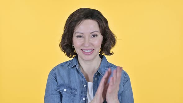 Cheering Old Woman Clapping on Yellow Background