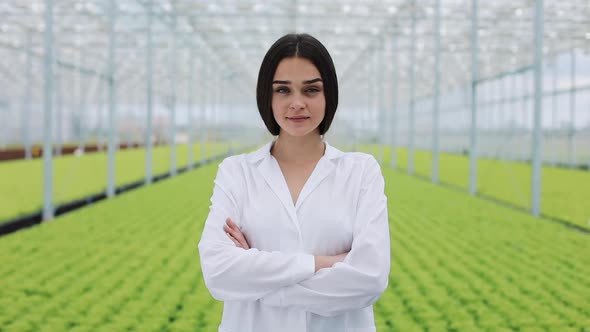 Agricultural Engineer in Greenhouse Wearing White Coat Looking Into the Camera. Portrait of a